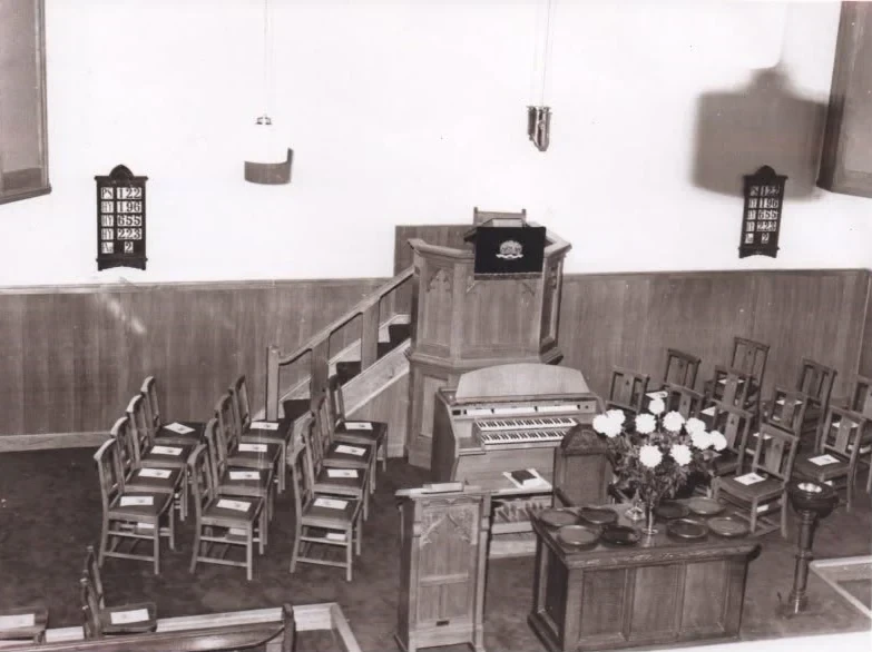 Historic interior of Cloughey Old Meeting House showing the pulpit, organ, communion table, seating and hymn boards